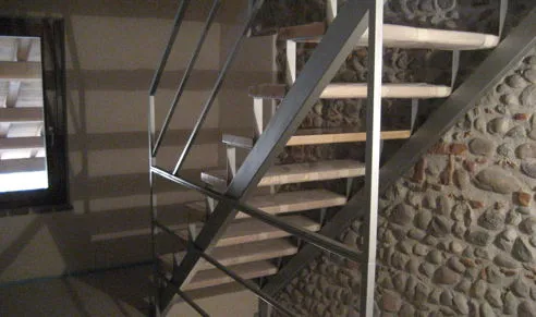 Scala in ferro di una taverna con scalini in legno